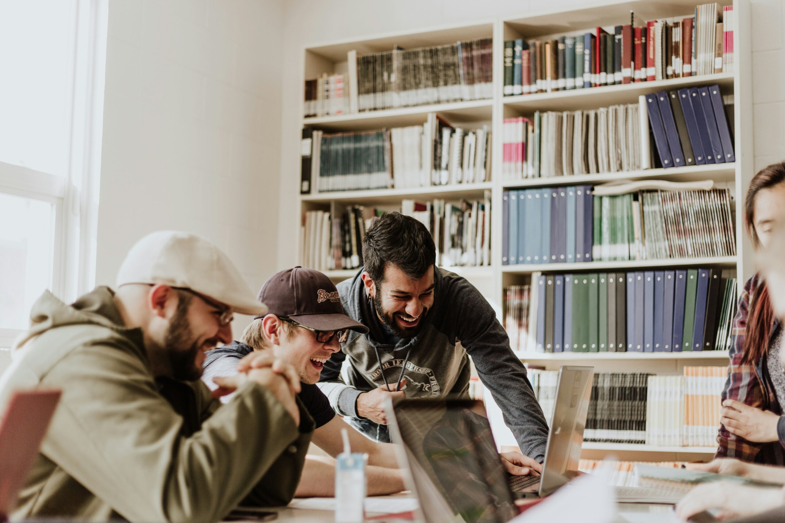 A team of people looks at a computer smiling. Photo by Priscilla Du Preez 🇨🇦 on Unsplash